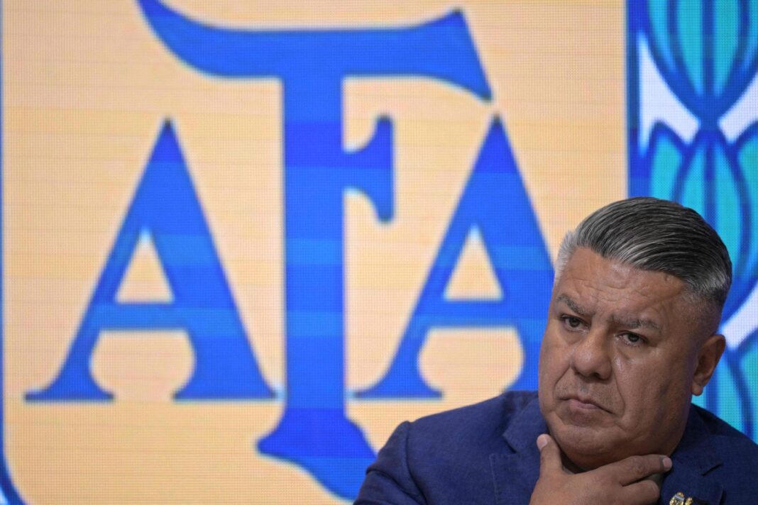 Símbolo de la AFA y un silbato de árbitro sobre un campo de fútbol.