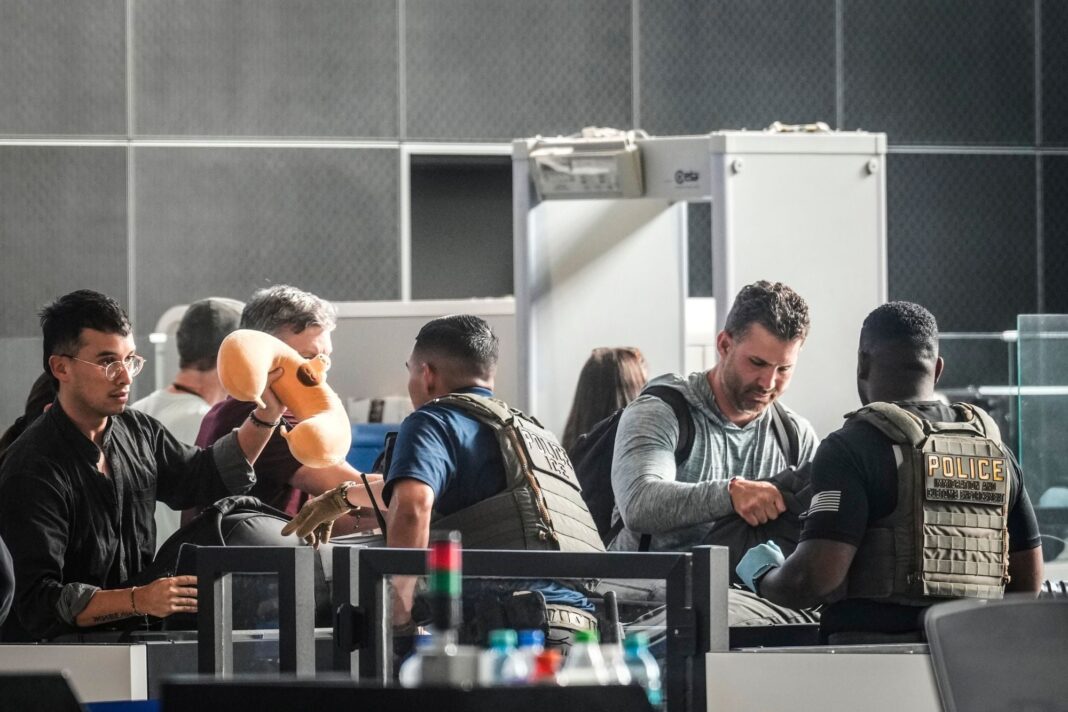 Pasajero colocando cargador portátil en equipaje de mano en aeropuerto