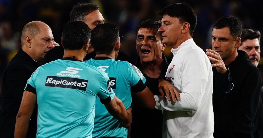 Jugadores de Boca Juniors e Independiente durante el partido en La Bombonera, con el árbitro Andrés Merlos en el fondo.