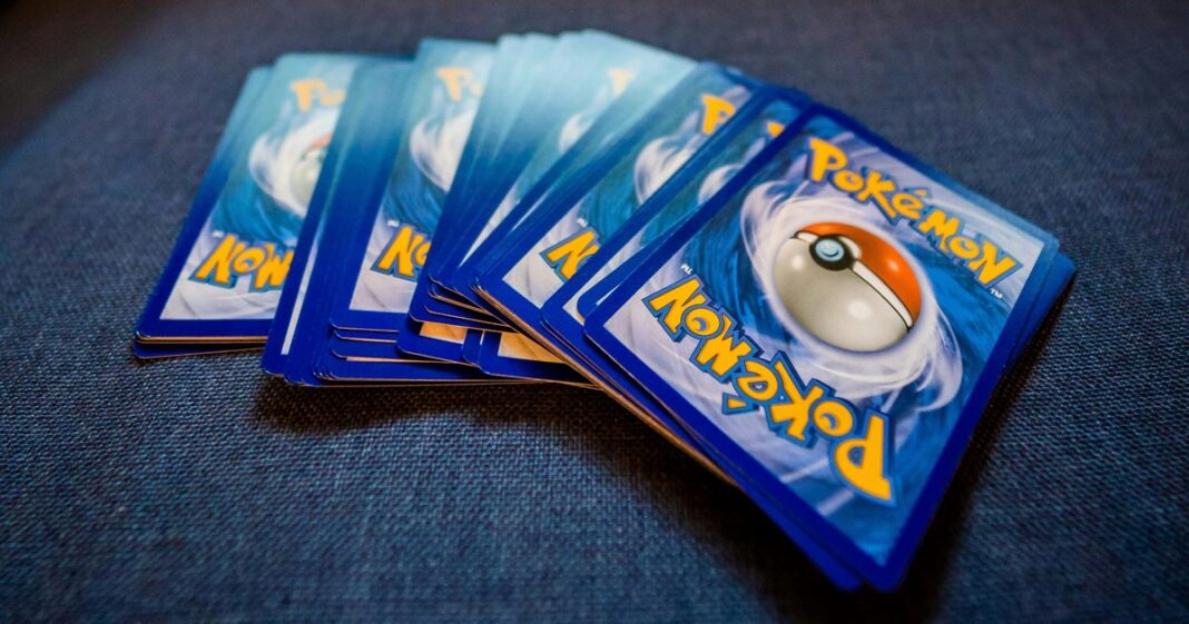Cartas coleccionables de Pokémon, entre ellas una de Charizard, sobre una superficie.
