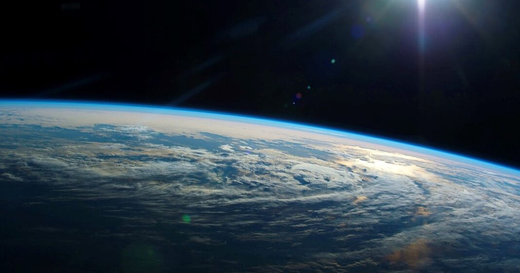 Ilustración conceptual de la Tierra y una represa, representando la redistribución de masa y su efecto en la rotación.