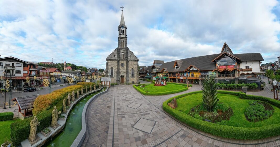 Vista de la arquitectura alpina y calles de Gramado, Brasil, con montañas de fondo.