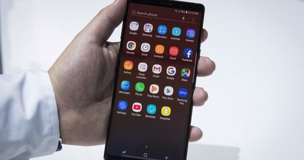 Persona sosteniendo un smartphone con un símbolo de candado y un escudo de seguridad digital superpuesto.