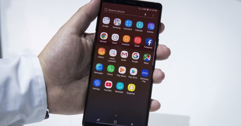 Persona sosteniendo un smartphone con un símbolo de candado y un escudo de seguridad digital superpuesto.