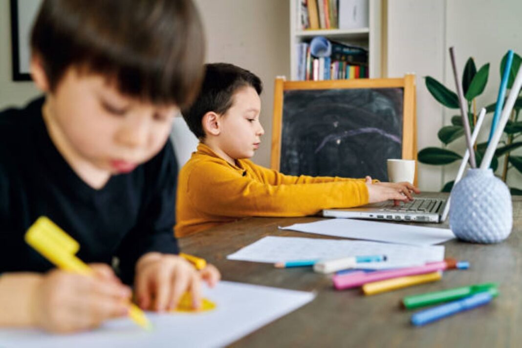 Tablet con iconos de inteligencia artificial sobre un escritorio en un aula escolar.