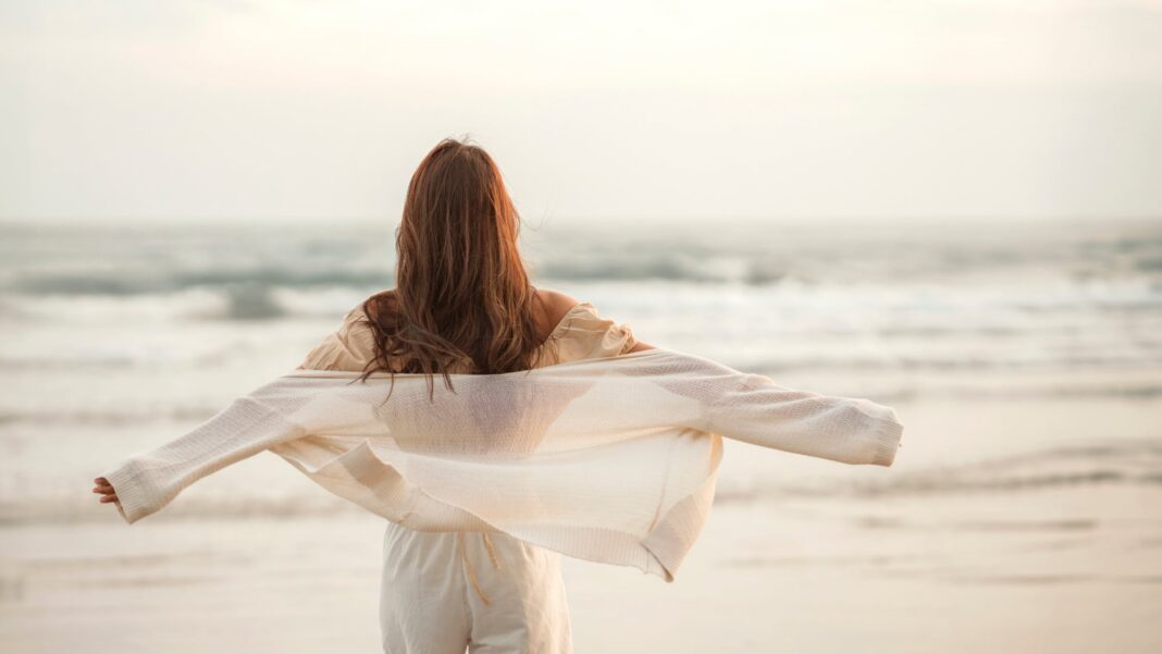 Persona leyendo noticias positivas en una tablet, con símbolos de like y corazones flotando alrededor