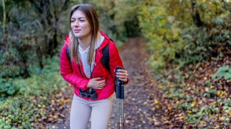 Persona consultando un mapa y una botella de agua, representando la planificación de un viaje saludable.