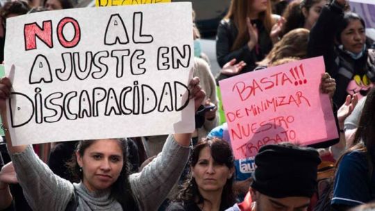 Manos sosteniendo un documento con el texto 'Proyecto de Ley de Discapacidad' sobre una mesa.