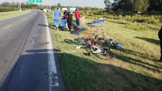 Ciclista en autopista con tráfico vehicular de fondo