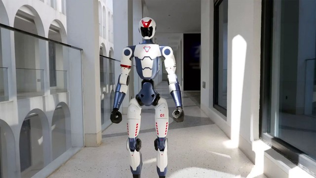 Robot humanoide Unitree R1 de color plateado realizando una pose dinámica sobre una superficie clara.