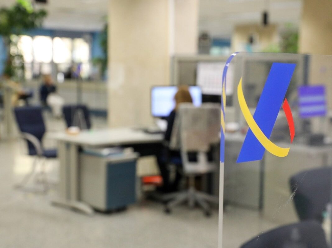 Oficina de la Agencia Tributaria con contribuyentes haciendo fila para declaración de Renta