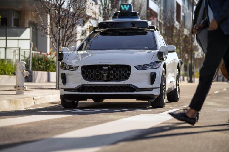 Auto Jaguar blanco de Waymo con sensores en el techo circulando en una calle de San Francisco