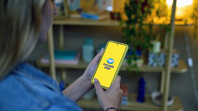 Persona usando Mercado Pago en su teléfono móvil con íconos de seguridad y candado