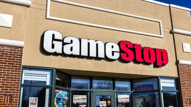 Logotipos de GameStop y eBay sobre fondo de gráficos financieros