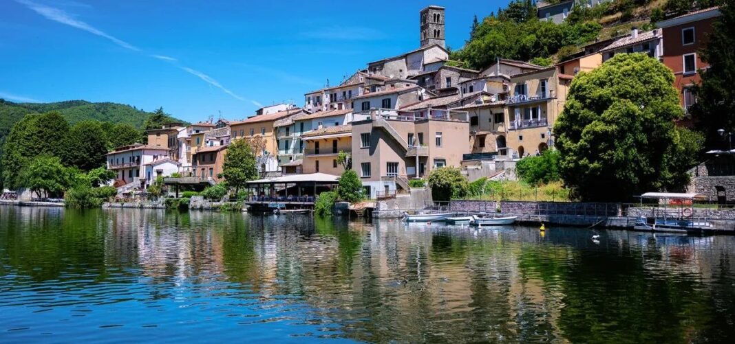 Vista del Lago di Piediluco con el pueblo de casas coloridas al fondo y montañas verdes