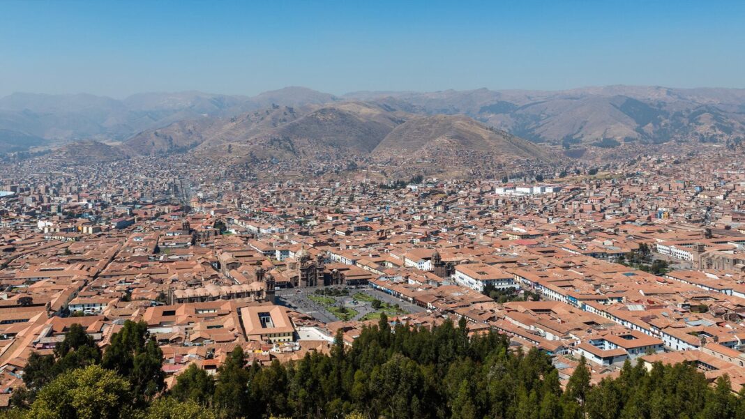 Vista de la ciudad de Cuzco con cielo nublado y montañas de fondo