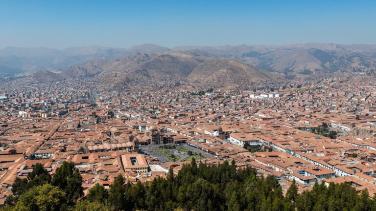 Vista de la ciudad de Cuzco con cielo nublado y montañas de fondo