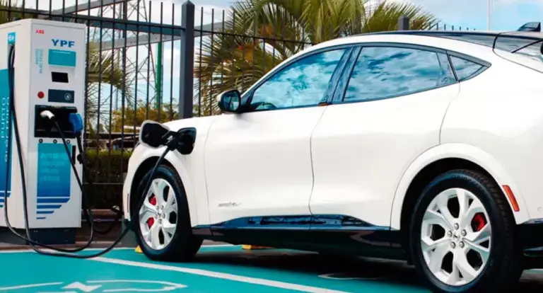 Autos electrificados estacionados en un concesionario argentino, con carteles de precios y modelos híbridos y eléctricos