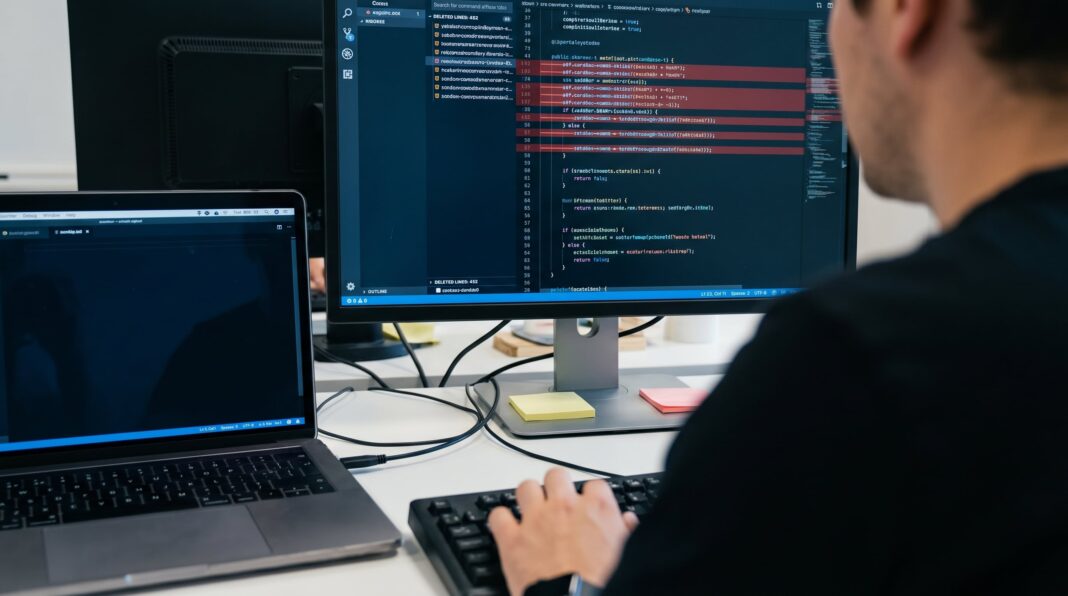 Estudiantes universitarios frente a pantallas con código de programación