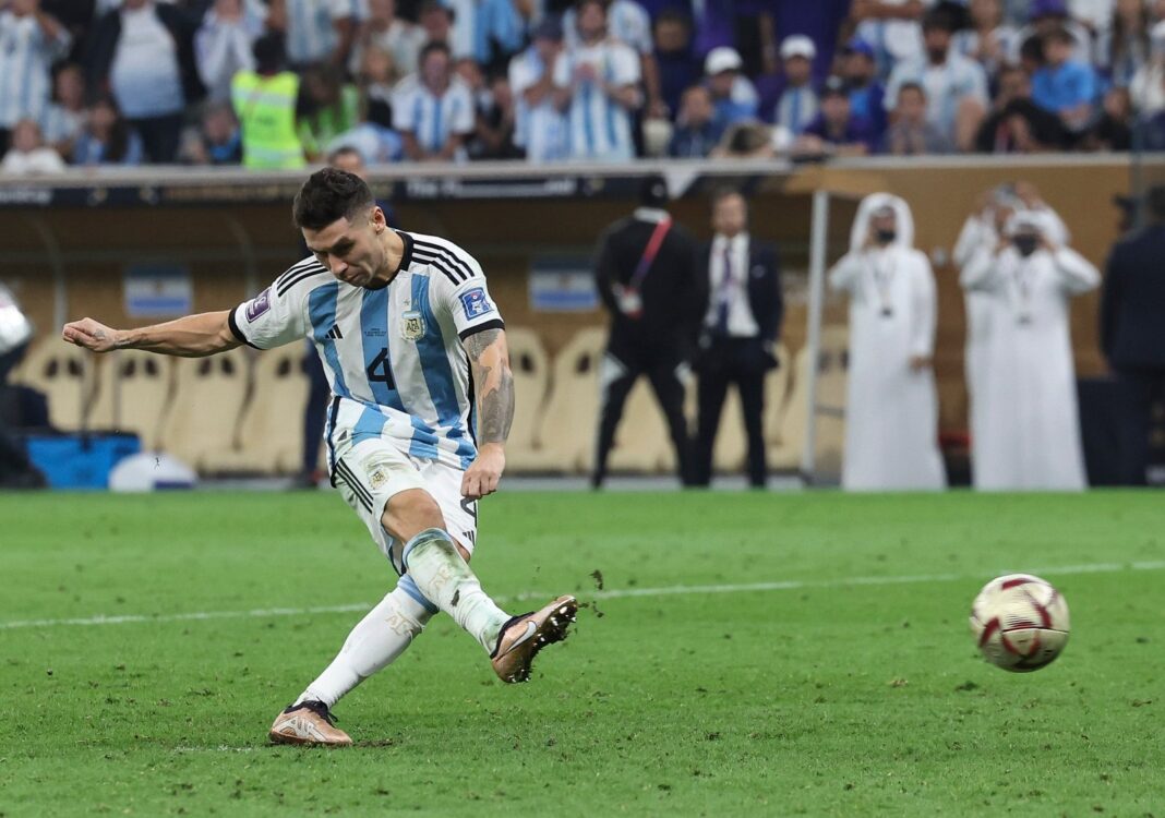 Jugador de fútbol pateando un penal en un estadio lleno
