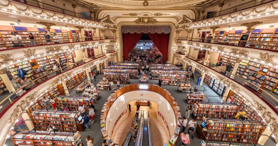 Interior de una librería con estantes llenos de libros y una persona revisando los títulos