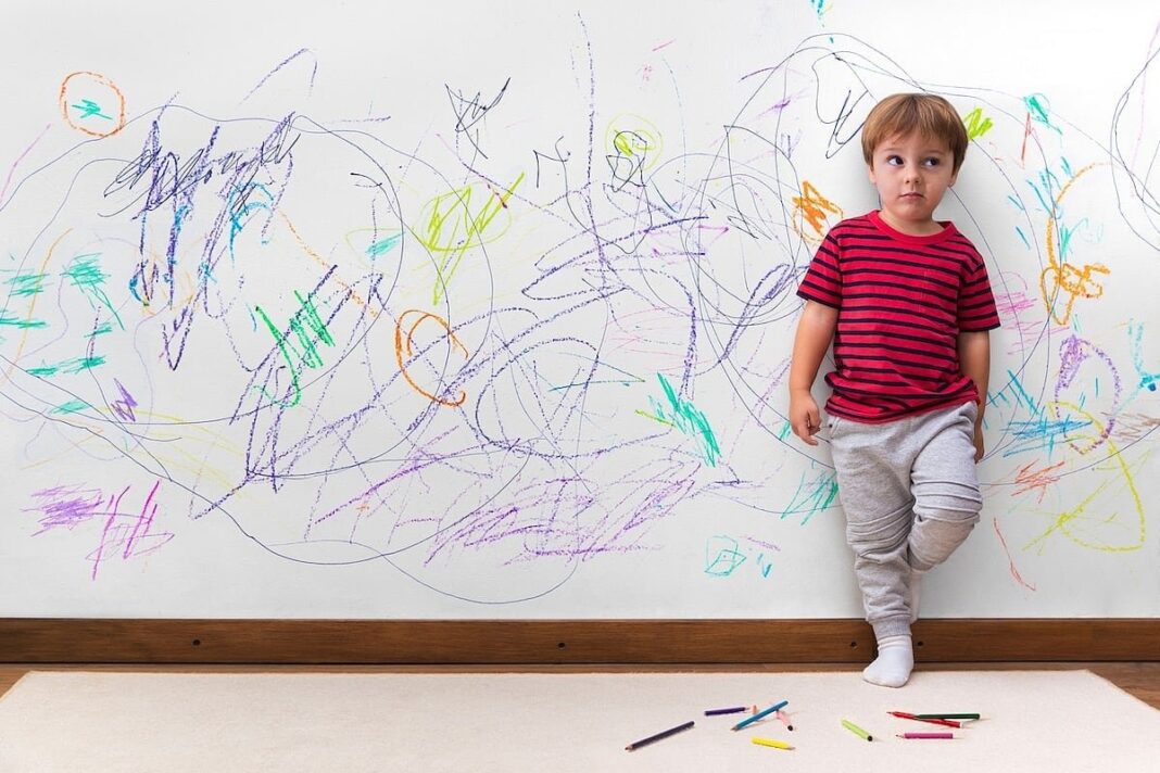 Niño pequeño con expresión seria mientras habla con un adulto