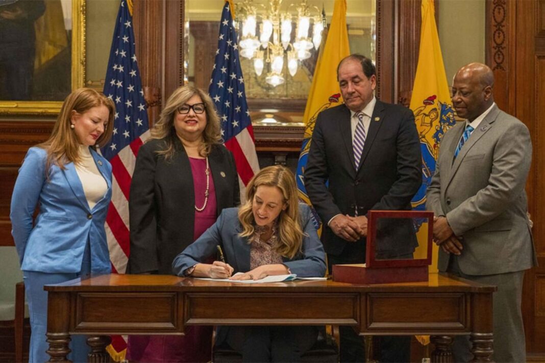 Mikie Sherrill firmando un documento en su despacho