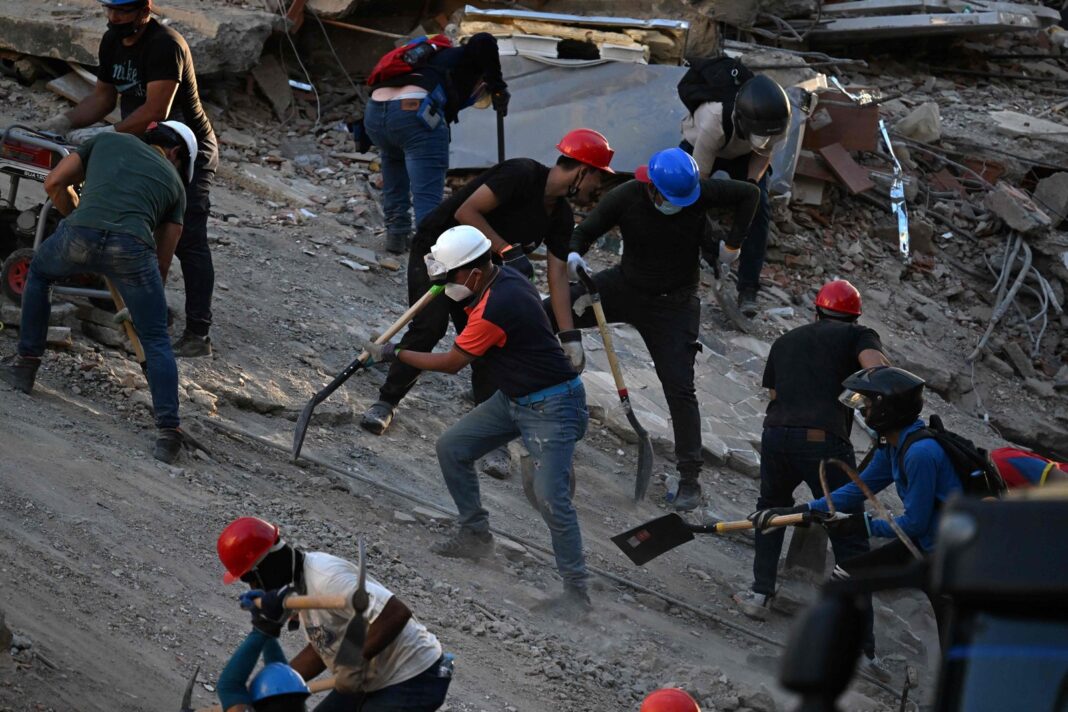 Voluntarios removiendo escombros con herramientas manuales en La Guaira tras el terremoto