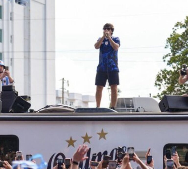 Ciro sobre el techo de un auto tocando la armónica durante el banderazo en Miami