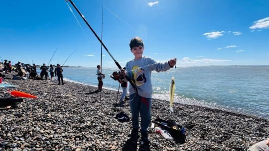 Niños pescando en la costa de Bahía San Blas durante concurso infantil