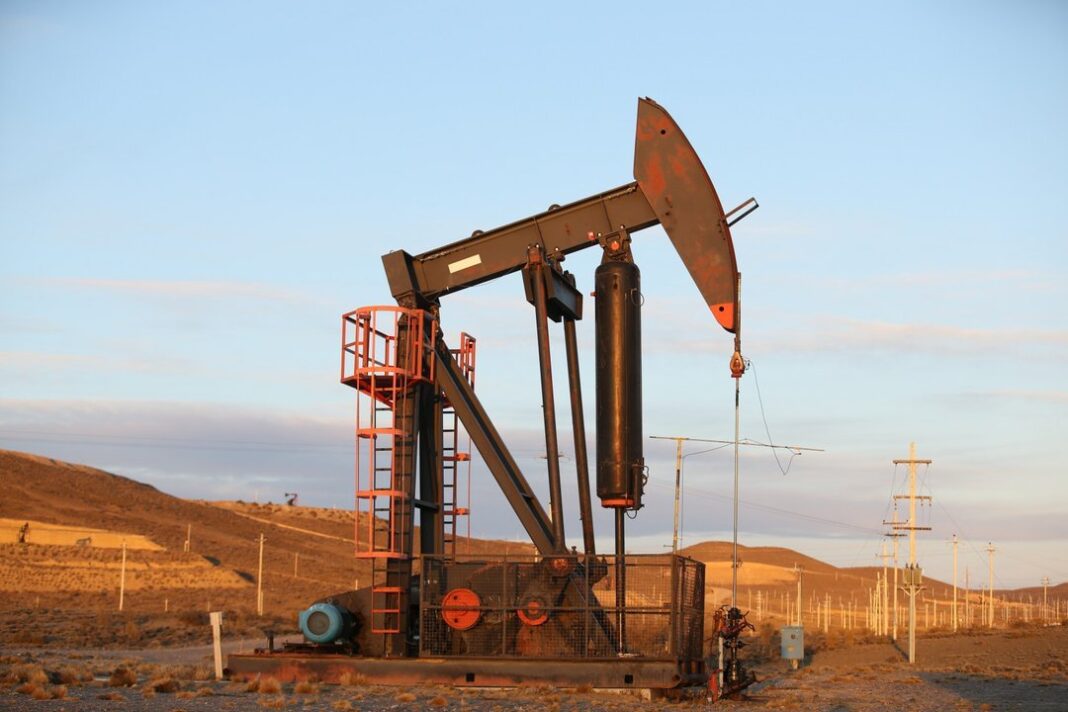 Bandera de Argentina y torres de extracción de petróleo