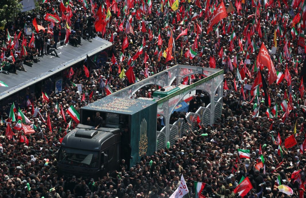 Ataúd de Ali Khamenei cubierto con la bandera iraní durante el funeral en Mashhad