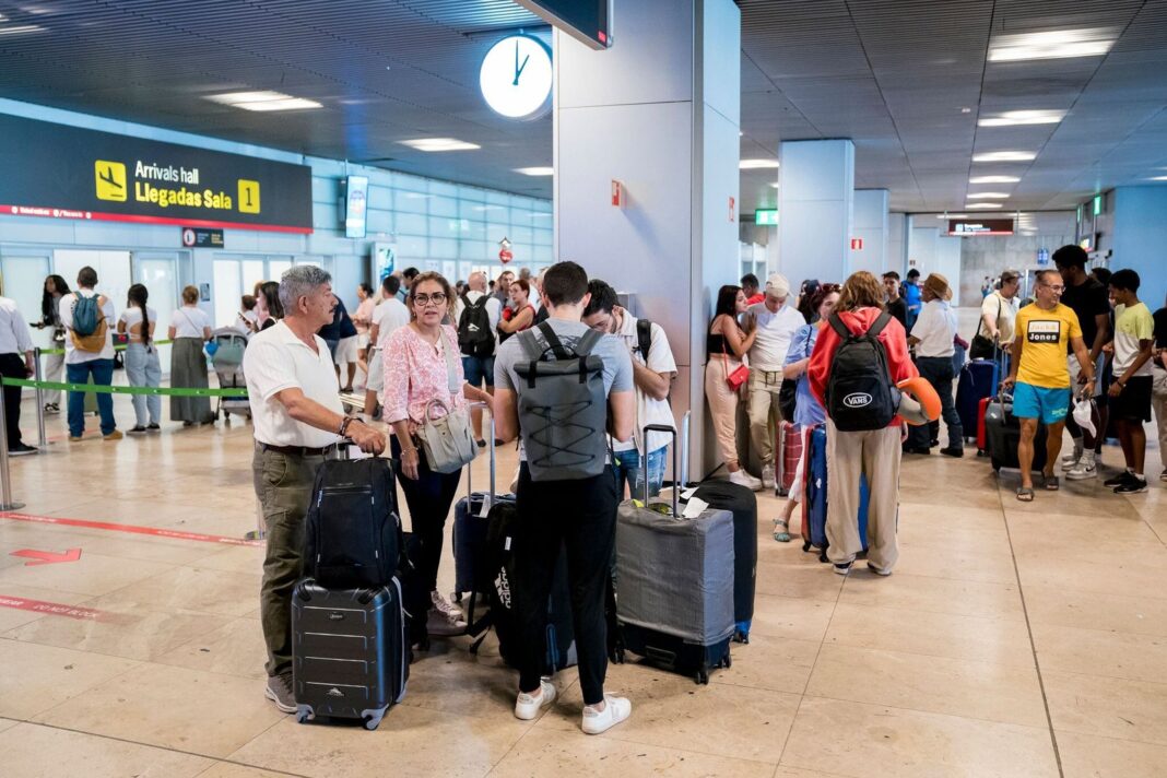 Pasajeros en aeropuerto de Barcelona esperando información sobre vuelo demorado
