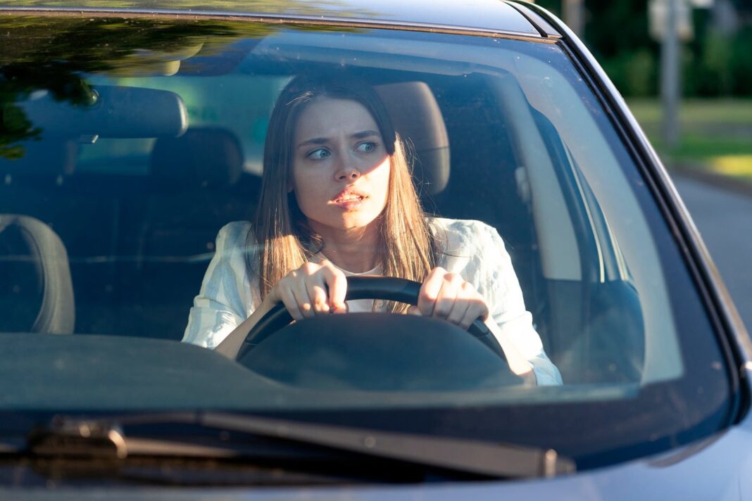 Persona conduciendo un auto con expresión de preocupación
