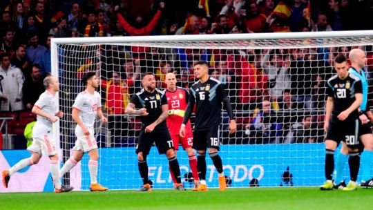 Jugadores de Argentina y España en un partido de fútbol