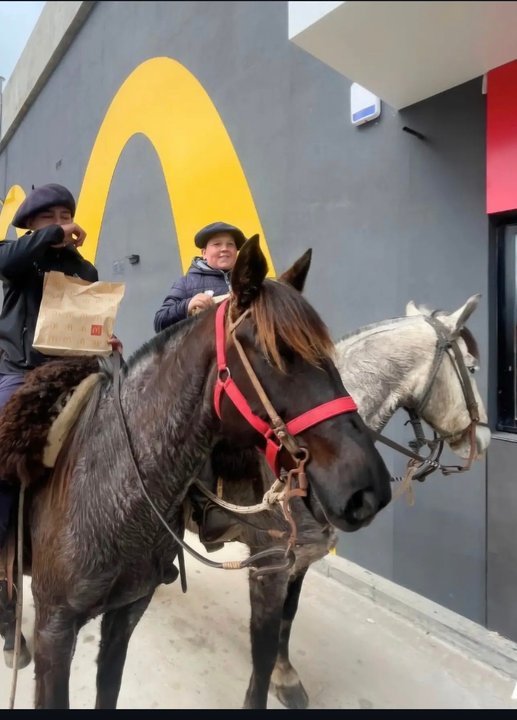Jinetes en el carril de atención al auto de un local de comida rápida en Junín