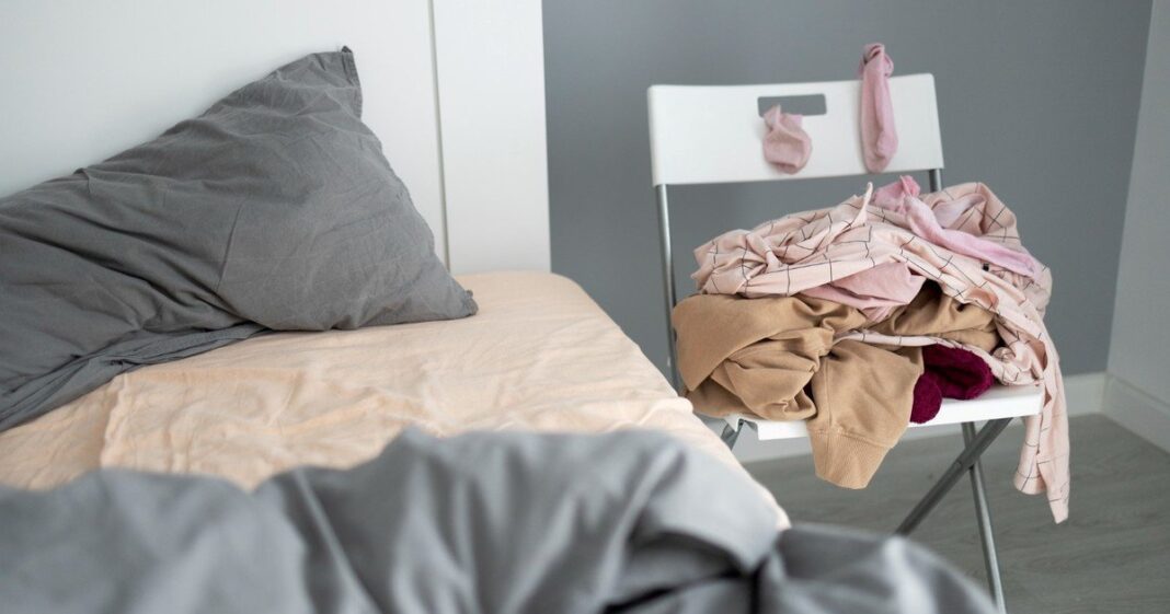 Ropa apilada sobre una silla en una habitación