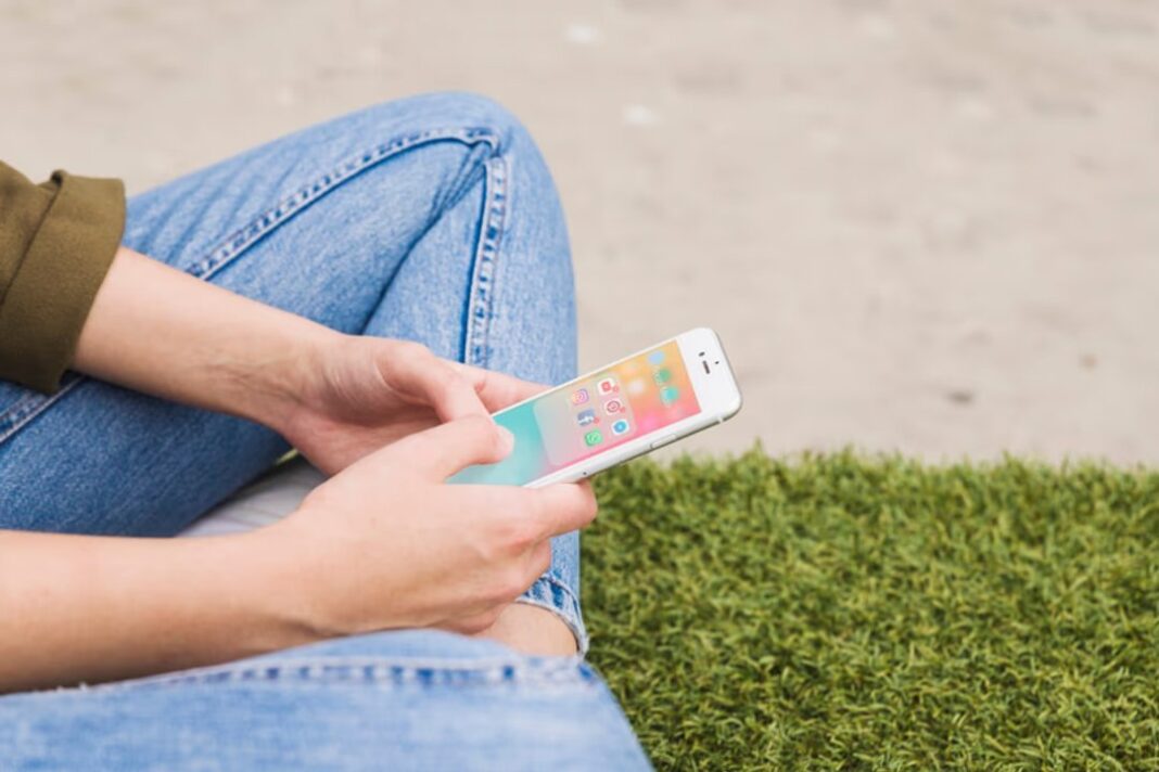 Imagen ilustrativa de un adolescente usando un teléfono móvil con aplicaciones de redes sociales