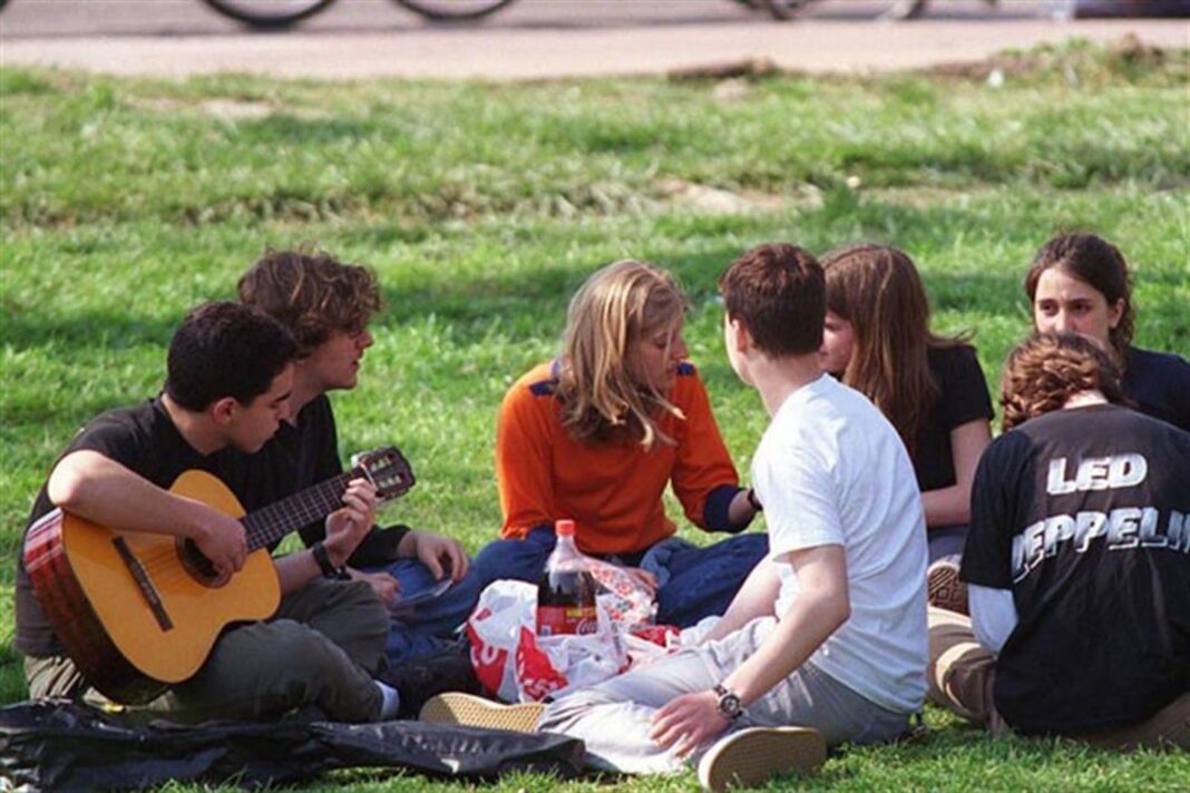 Estudiantes celebrando al aire libre en un parque durante el Día del Estudiante y de la Primavera