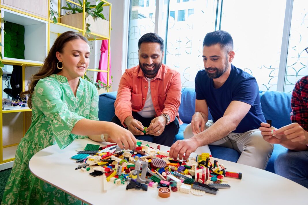 Ladrillos de plástico de colores apilados formando una construcción sobre una mesa