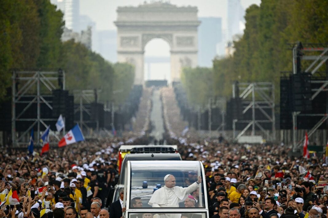 El papa León XIV saluda a los fieles desde el papamóvil durante la misa en los Campos Elíseos, en París.