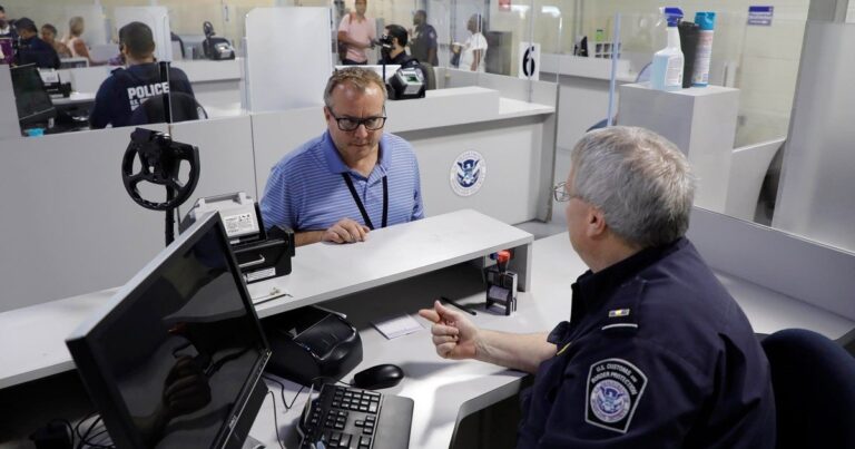 Agente de la CBP revisando un teléfono celular en un control fronterizo