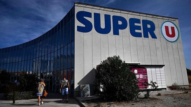 Interior de un supermercado con góndolas de productos frescos y congelados
