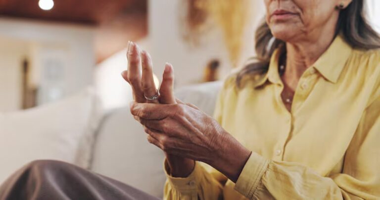 Persona con artritis reumatoidea sosteniendo sus manos durante una consulta médica