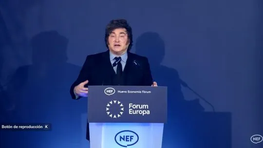 Panel azul sin logotipos comerciales detrás del presidente Javier Milei durante su discurso en Madrid