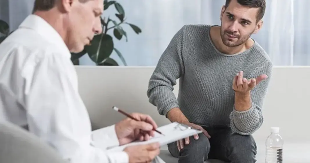 Persona adulta observando su teléfono móvil en un entorno laboral